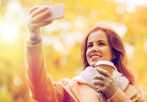 女人以智能手机在秋天公园自拍照 — 图库照片