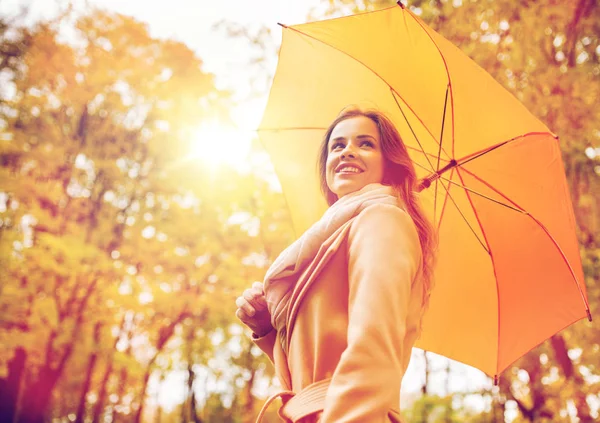 Donna felice con ombrellone passeggiando nel parco autunnale — Foto Stock