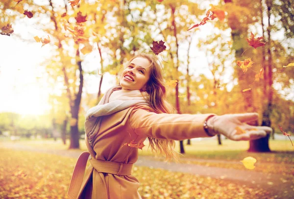 Mujer feliz divirtiéndose con hojas en el parque de otoño —  Fotos de Stock