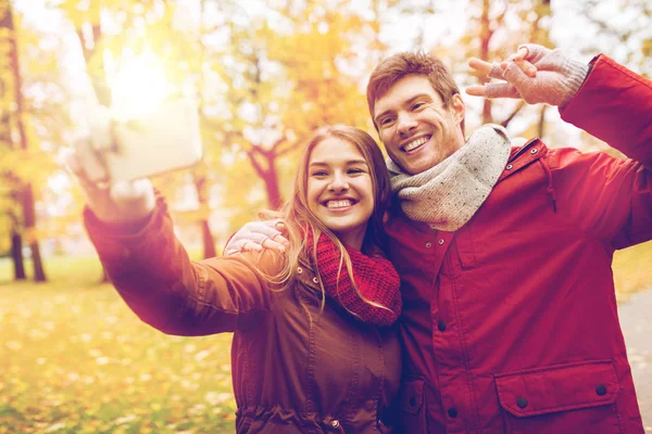 Casal tirando selfie por smartphone no parque de outono — Fotografia de Stock