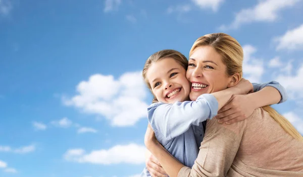 Счастливая семья девочки и матери, обнимающиеся над небом — стоковое фото