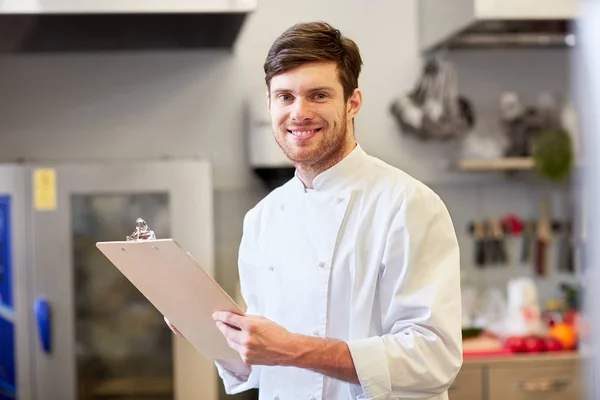 Szef kuchni z schowka robienie zapasów w restauracji — Zdjęcie stockowe