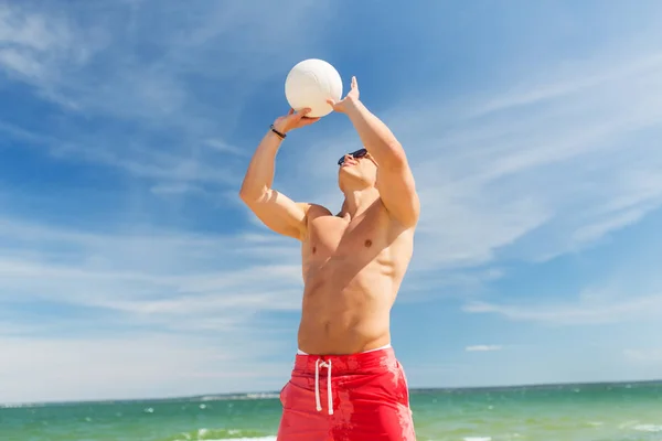Νεαρός άνδρας με μπάλα παίζει βόλεϊ στην παραλία — Φωτογραφία Αρχείου