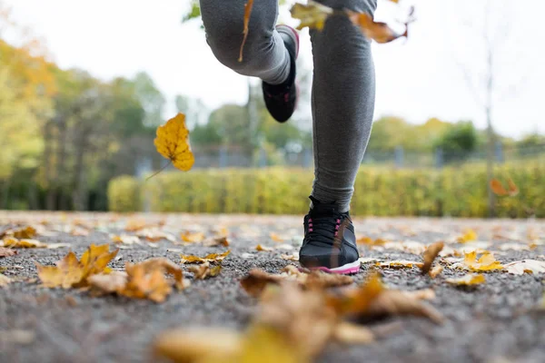 Närbild på ung kvinna kör i höst park — Stockfoto