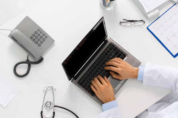 Lekarz rękami pisania na laptopa w klinice — Zdjęcie stockowe