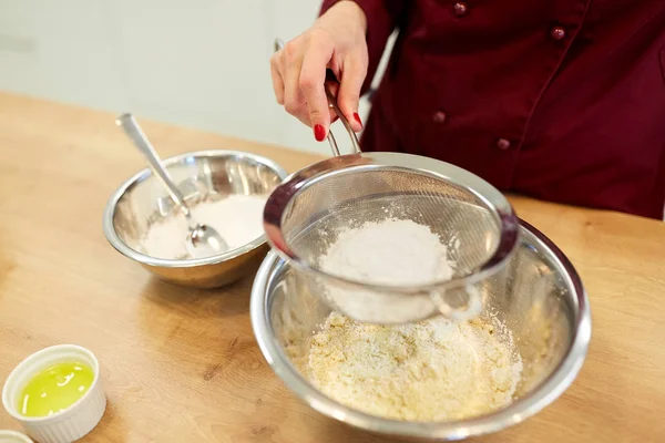 Шеф-повар просеивает муку в миске, делая тесто или тесто — стоковое фото