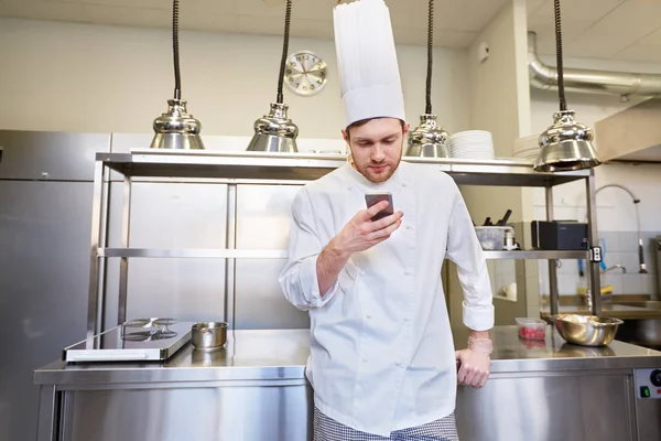 Chef cuisinier avec smartphone au restaurant cuisine — Photo