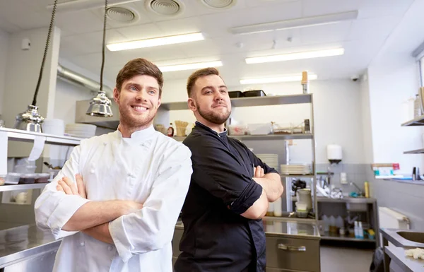 Feliz chef sonriente y cocinar en la cocina del restaurante — Foto de Stock