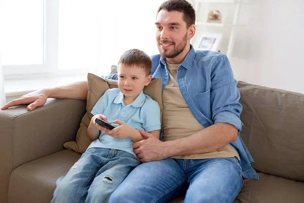 Isä ja poika kauko television katselu kotona — kuvapankkivalokuva