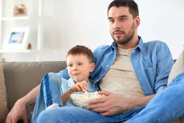 Padre e hijo con palomitas de maíz viendo la televisión en casa — Foto de Stock