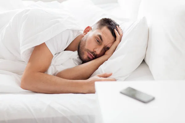 Jonge man kijkend naar smartphone — Stockfoto