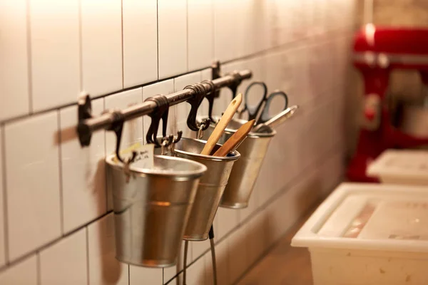 Bakery kitchen tools hanging on wall in buckets — Stock Photo, Image