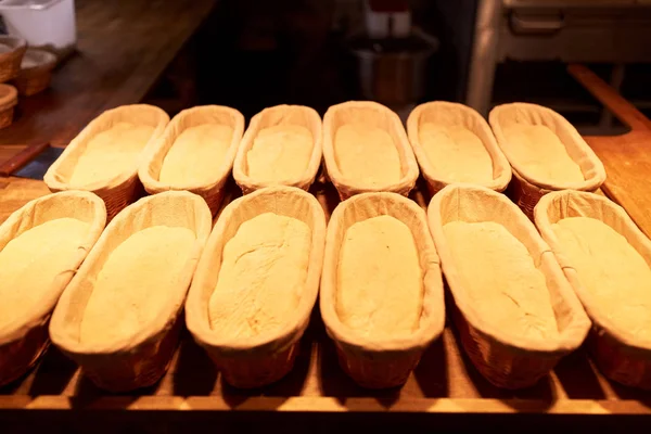 Masa de pan de levadura en cestas en la cocina de panadería —  Fotos de Stock