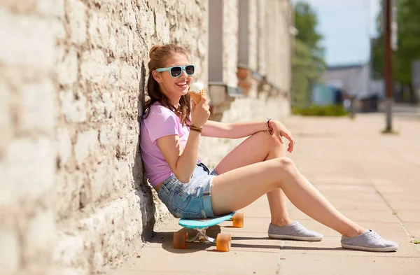 Feliz adolescente chica con longboard comer helado — Foto de Stock