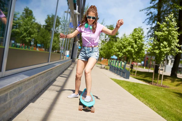 Feliz adolescente chica en tonos cabalgando en longboard —  Fotos de Stock