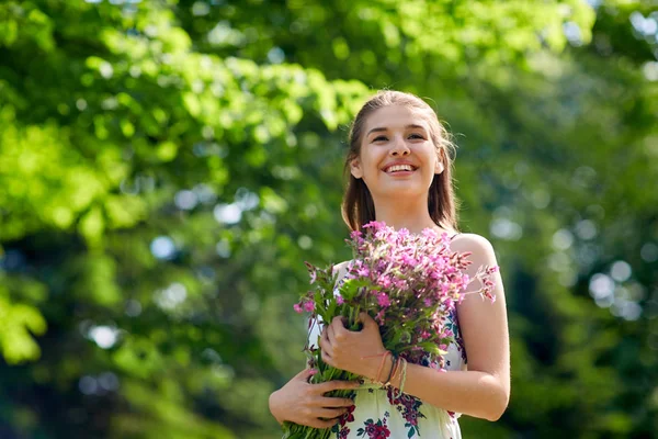 여름 공원에 꽃과 함께 행복 한 젊은 여자 — 스톡 사진