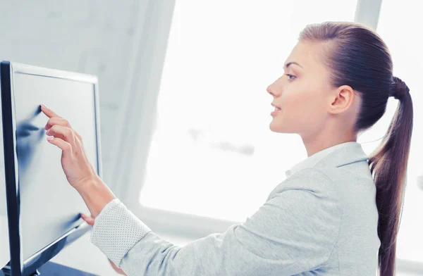 Mujer de negocios sonriente con pantalla táctil en la oficina —  Fotos de Stock