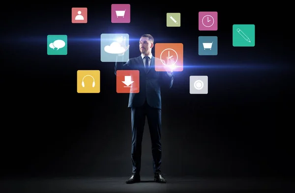 Бизнесмен с иконками меню на виртуальном экране — стоковое фото