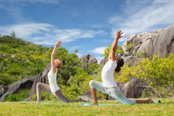 Coppia che fa yoga in posa affondo basso all'aperto — Foto Stock