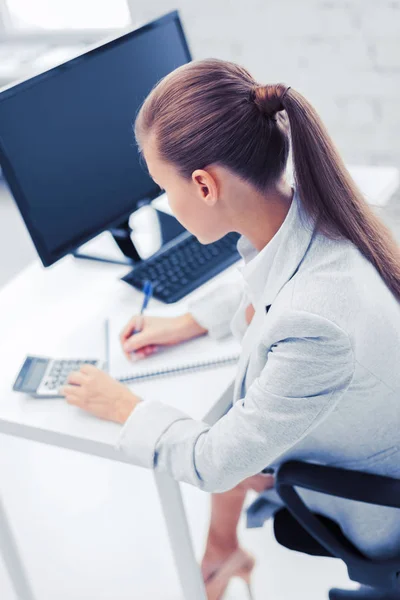 Affärskvinna med bärbara datorer och miniräknare — Stockfoto