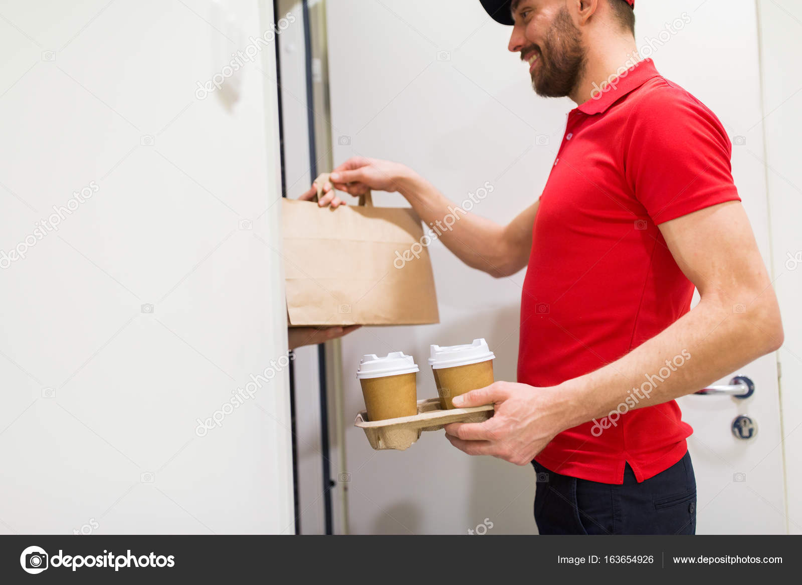 Delivery man with coffee and food at customer home Stock Photo by ©Syda