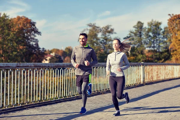 Happy couple running outdoors — Stock Photo, Image