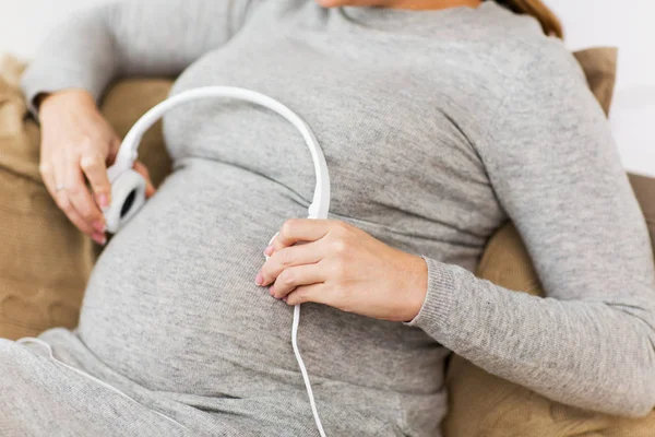 Schwangere mit Kopfhörern hört Musik — Stockfoto