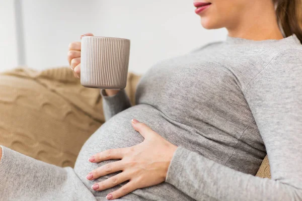 幸福的怀孕女人，坐在家里喝茶的杯 — 图库照片