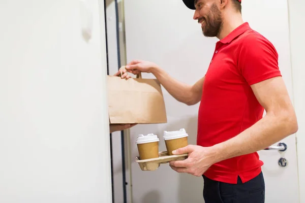 Homem de entrega com café e comida em casa do cliente — Fotografia de Stock