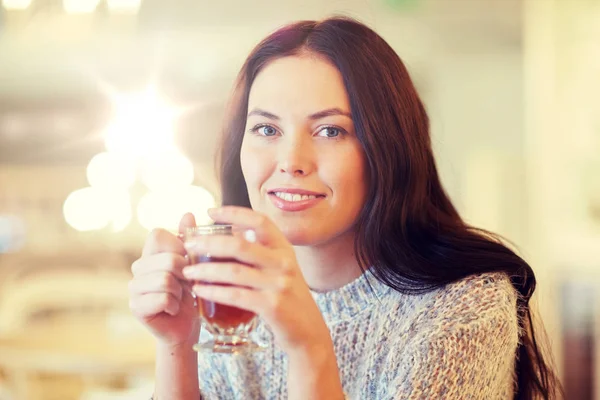 Smiling young woman drinking tea at cafe Stock Photo