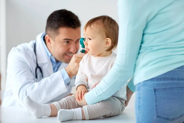 Doctor with otoscope checking baby ear at clinic Royalty Free Stock Images