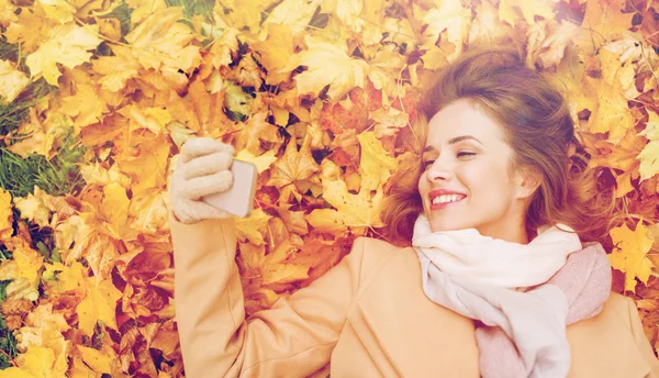 秋天的落叶，以智能手机拍照的女人 — 图库照片