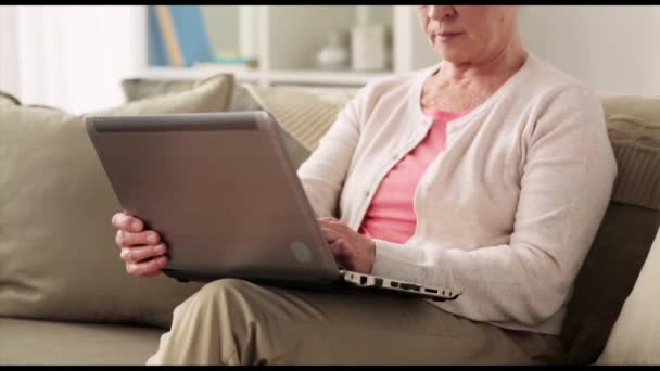 Счастливая пожилая женщина с ноутбуком дома — стоковое видео
