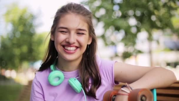 Adolescente feliz con auriculares y longboard — Vídeos de Stock