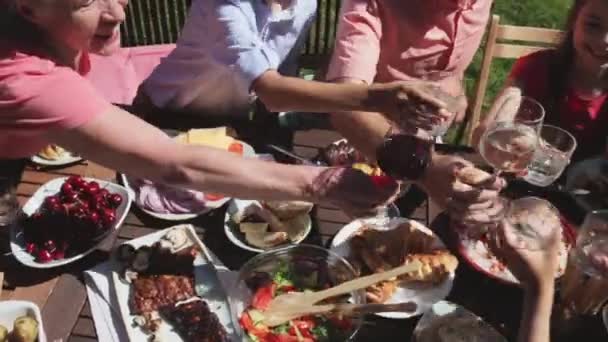 Счастливая семья с ужином или вечеринкой в летнем саду — стоковое видео