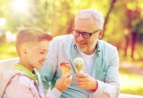 Старий і хлопчик їсть морозиво в літньому парку — стокове фото