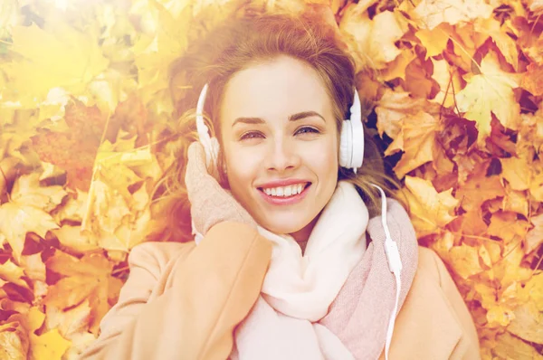 Žena s sluchátka poslouchat hudbu na podzim — Stock fotografie