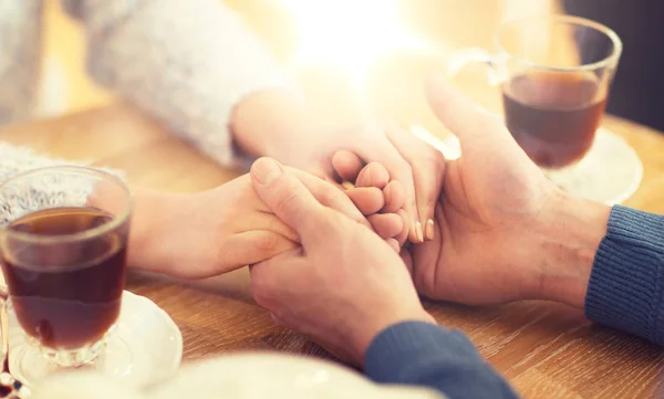 Primer plano de pareja cogida de la mano en el restaurante — Foto de Stock