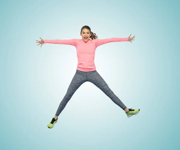 Щаслива усміхнена спортивна молода жінка стрибає в повітрі — стокове фото
