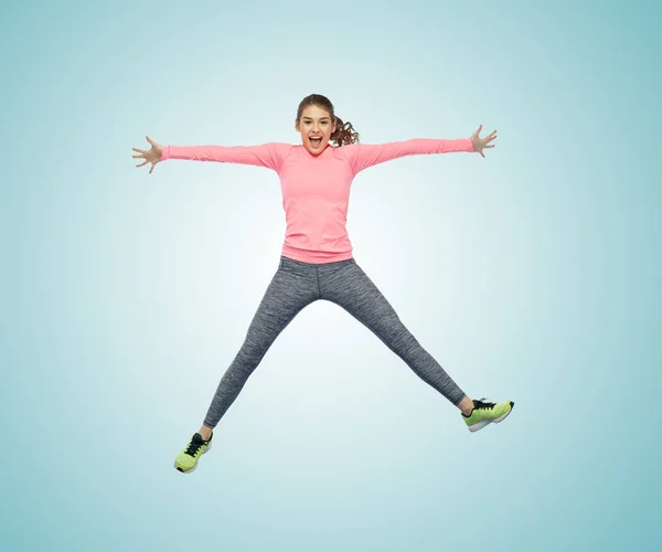 Happy smiling sporty young woman jumping in air — Stock Photo, Image