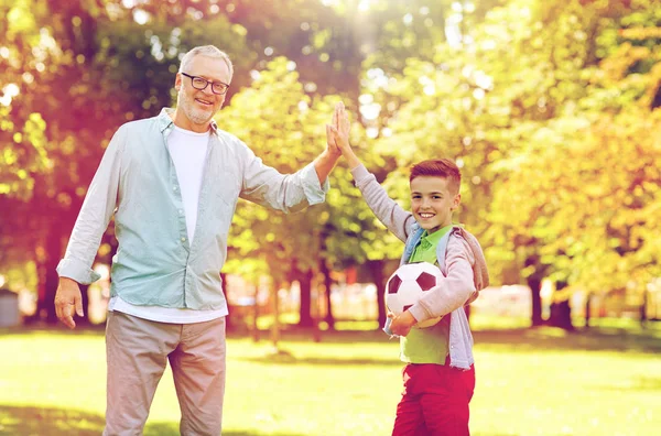 Viejo hombre y niño con pelota de fútbol haciendo cinco —  Fotos de Stock