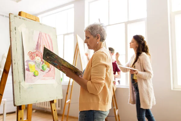 Woman artist with easel painting at art school — Stock Photo, Image