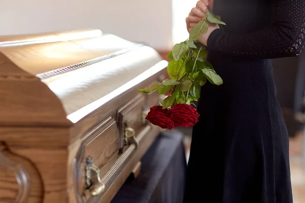 Mujer con rosas rojas y ataúd en el funeral —  Fotos de Stock