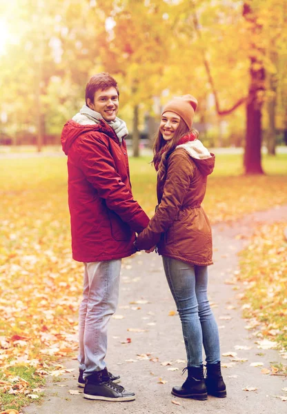 Felice giovane coppia a piedi nel parco autunnale — Foto Stock