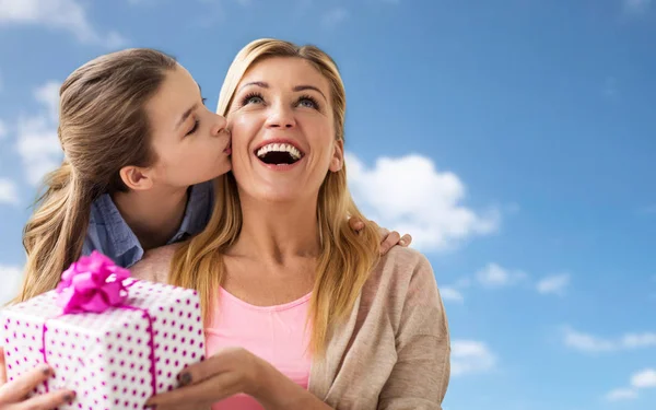 Meisje geven verjaardagscadeau aan moeder over hemel — Stockfoto