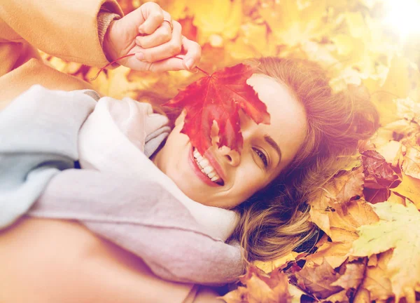 Belle femme heureuse allongée sur des feuilles d'automne — Photo