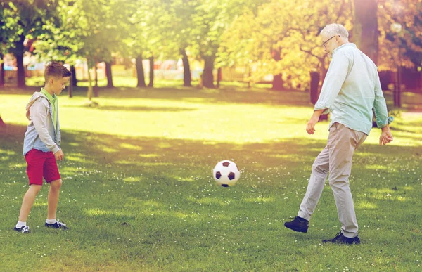 Viejo hombre y niño jugando al fútbol en el parque de verano — Foto de Stock