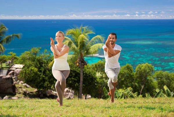 Sorrindo casal fazendo exercícios de ioga ao ar livre — Fotografia de Stock