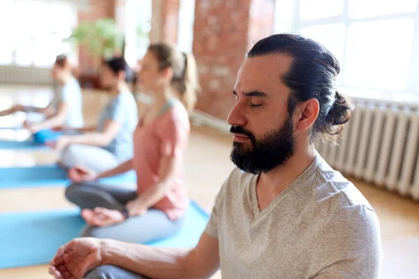 Bir grup insanla yoga stüdyosunda meditasyon yapan bir adam. — Stok fotoğraf