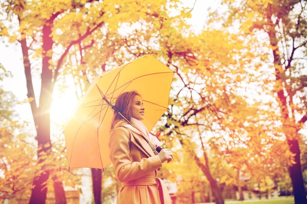 Szczęśliwa kobieta z parasolem spaceru w jesiennym parku — Zdjęcie stockowe